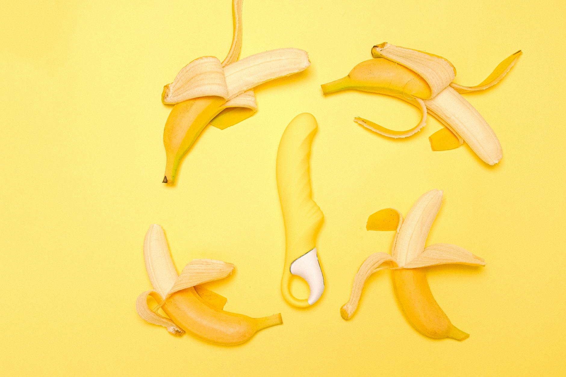 Vibrador de limão com sucção em fundo amarelo com bananas