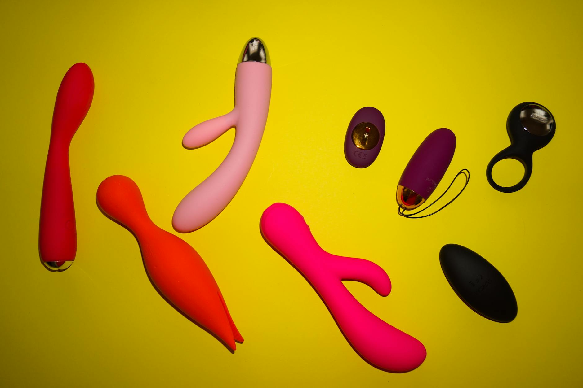 Various lemon vibrators and sexual wellness toys arranged on a bright yellow surface